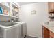 A spacious laundry room with wooden cabinetry and a washer and dryer at 8626 E San Miguel E Ave, Scottsdale, AZ 85250