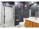 Dark bathroom featuring a walk-in shower, framed posters, and a modern sink at 864 W Blue Ridge Dr, San Tan Valley, AZ 85140