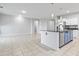 Modern kitchen with stainless steel appliances, island with seating, and seamless flow to living area at 864 W Blue Ridge Dr, San Tan Valley, AZ 85140