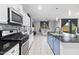 Modern kitchen with stainless steel appliances, dark countertops, and bright adjacent living space at 864 W Blue Ridge Dr, San Tan Valley, AZ 85140