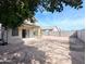 Wide shot of the backyard with a block fence, brick-covered patio, and covered porch at 8861 W Paradise Dr, Peoria, AZ 85345