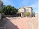 Home's backyard featuring a brick-covered patio, block fence, and mature trees at 8861 W Paradise Dr, Peoria, AZ 85345