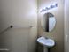 Cozy bathroom with pedestal sink, round mirror, and decorative lighting at 8861 W Paradise Dr, Peoria, AZ 85345