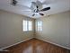 A standard bedroom with a wood floor, ceiling fan and natural light at 8861 W Paradise Dr, Peoria, AZ 85345