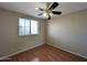 A bedroom with a window, ceiling fan and a wood floor at 8861 W Paradise Dr, Peoria, AZ 85345