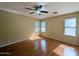 Spacious bedroom with wood floors, natural light from two windows, and a ceiling fan at 8861 W Paradise Dr, Peoria, AZ 85345