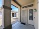 Front door with a security screen on a covered porch area with decorative columns at 8861 W Paradise Dr, Peoria, AZ 85345