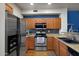 Modern kitchen with stainless steel appliances, granite countertops, wood cabinets and double sink at 910 W Aspen Way, Gilbert, AZ 85233