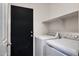 Bright laundry room features a side-by-side washer and dryer and a shelf for storage above appliances at 910 W Aspen Way, Gilbert, AZ 85233