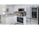 Stainless steel appliances, grey counters, white cabinets and diamond pattern backsplash in this well appointed kitchen at 9115 W Kimberly Way, Peoria, AZ 85382