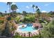 Aerial view of a pristine pool with a covered seating area surrounded by palm trees in a lush community at 9115 W Kimberly Way, Peoria, AZ 85382