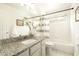 Bright bathroom featuring granite counters, white cabinets, and tub with shower at 9224 E Windrose Dr, Scottsdale, AZ 85260