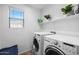 Well-lit laundry room with modern washer and dryer, and ample shelving at 925 E Doris St, Avondale, AZ 85323