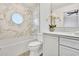 Bathroom with marble-tiled shower, a unique round window, and a modern vanity at 9430 N 25Th St, Phoenix, AZ 85028