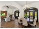 Open-concept dining room featuring a chandelier, a round table, arched doorways, and a view to the living area at 10040 E Happy Valley Rd # 289, Scottsdale, AZ 85255