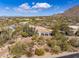 Exterior view of a luxury home surrounded by desert landscaping with mountain views, featuring a three-car garage and tile roof at 10040 E Happy Valley Rd # 289, Scottsdale, AZ 85255