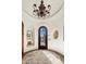 Grand foyer with a decorative chandelier, a circular rug, an arched doorway, and architectural details at 10040 E Happy Valley Rd # 289, Scottsdale, AZ 85255