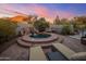 Relaxing hot tub with stone waterfall feature, surrounded by lush landscaping and illuminated by a colorful sunset at 10040 E Happy Valley Rd # 289, Scottsdale, AZ 85255