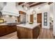 Spacious kitchen boasts an island, wooden cabinetry, stainless steel appliances, and designer pendant lighting at 10040 E Happy Valley Rd # 289, Scottsdale, AZ 85255