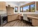 Well-equipped laundry room featuring modern washer, dryer, sink, and ample counter space with desk at 10040 E Happy Valley Rd # 289, Scottsdale, AZ 85255