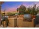 Outdoor grill area with stainless steel grill and tiled countertops against a scenic sunset backdrop at 10040 E Happy Valley Rd # 289, Scottsdale, AZ 85255