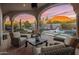 Covered patio featuring comfortable seating areas overlooking a stunning pool and sunset at 10040 E Happy Valley Rd # 289, Scottsdale, AZ 85255