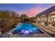 Stunning pool with integrated lounge chairs and waterfall feature, set against a beautiful twilight sky at 10040 E Happy Valley Rd # 289, Scottsdale, AZ 85255