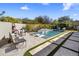 Backyard pool with water feature, in-pool lounge chairs, desert landscaping, and a tiled patio, perfect for outdoor relaxation at 10040 E Happy Valley Rd # 289, Scottsdale, AZ 85255