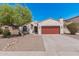 Inviting home featuring desert landscaping, a red garage door, and a lush, mature tree at 10212 W Wier Ave, Tolleson, AZ 85353