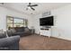 Bright living room featuring a ceiling fan, a large window, and modern decor with a cozy sofa at 10212 W Wier Ave, Tolleson, AZ 85353