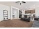 Spacious living area with a ceiling fan, a dark sofa, open layout leading to the kitchen at 10212 W Wier Ave, Tolleson, AZ 85353