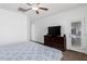 This primary bedroom features a ceiling fan, and access to the backyard through a glass door at 10212 W Wier Ave, Tolleson, AZ 85353