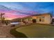 Lush backyard with a putting green, outdoor seating area, and a sparkling pool under romantic string lights at 10455 E Thornton Ave, Mesa, AZ 85212