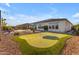 Expansive backyard featuring a putting green, lounge area, and lush landscaping, perfect for outdoor entertaining at 10455 E Thornton Ave, Mesa, AZ 85212