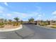 Welcoming gated community entrance with stone pillars, mature trees, and pristine landscaping at 10455 E Thornton Ave, Mesa, AZ 85212