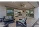 Covered patio featuring comfortable seating with a view of the home's interior through sliding glass doors at 10455 E Thornton Ave, Mesa, AZ 85212