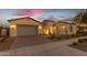 Charming single-story home with a three-car garage, brick paved driveway, and manicured landscaping at dusk at 10455 E Thornton Ave, Mesa, AZ 85212