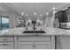 A kitchen island features granite countertops and a sink, with views of the bright, open-concept living area at 10455 E Thornton Ave, Mesa, AZ 85212