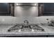 A sleek stovetop and decorative kettle complement the granite countertops and modern cabinetry in this stylish kitchen at 10455 E Thornton Ave, Mesa, AZ 85212