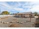 Backyard of property with gravel landscaping, rock detail, patio, and desert vegetation at 10620 W Snead Dr, Sun City, AZ 85351