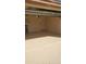 View of a clean garage with a painted floor and cinder block wall at 10620 W Snead Dr, Sun City, AZ 85351