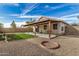 Spacious backyard featuring a covered patio, gravel, grass, and a fire pit at 1165 W 4Th Ave, Apache Junction, AZ 85120