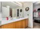 Bathroom featuring double sinks with a large mirror and wood cabinets at 1165 W 4Th Ave, Apache Junction, AZ 85120