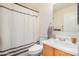 A well-lit bathroom with a toilet, sink, vanity, mirror, and shower curtain at 1165 W 4Th Ave, Apache Junction, AZ 85120