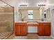 Bathroom with dual sinks, wood cabinets and a large mirror at 119 W Leatherwood Ave, San Tan Valley, AZ 85140