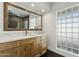 Bright bathroom with marble countertops, wood cabinets, stylish mirror, and privacy window at 11942 N 95Th St, Scottsdale, AZ 85260