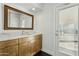 Bright bathroom featuring a wood vanity with marble countertop and a decorative gold mirror at 11942 N 95Th St, Scottsdale, AZ 85260