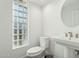 Bright powder room with a unique glass block window and a modern pedestal sink at 11942 N 95Th St, Scottsdale, AZ 85260