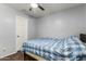 A cozy bedroom featuring wood floors, a ceiling fan, and a white door at 12312 N 147Th Ln, Surprise, AZ 85379