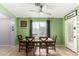 Bright dining room with a wooden table, six chairs, tile flooring, and a large window with natural light at 12312 N 147Th Ln, Surprise, AZ 85379